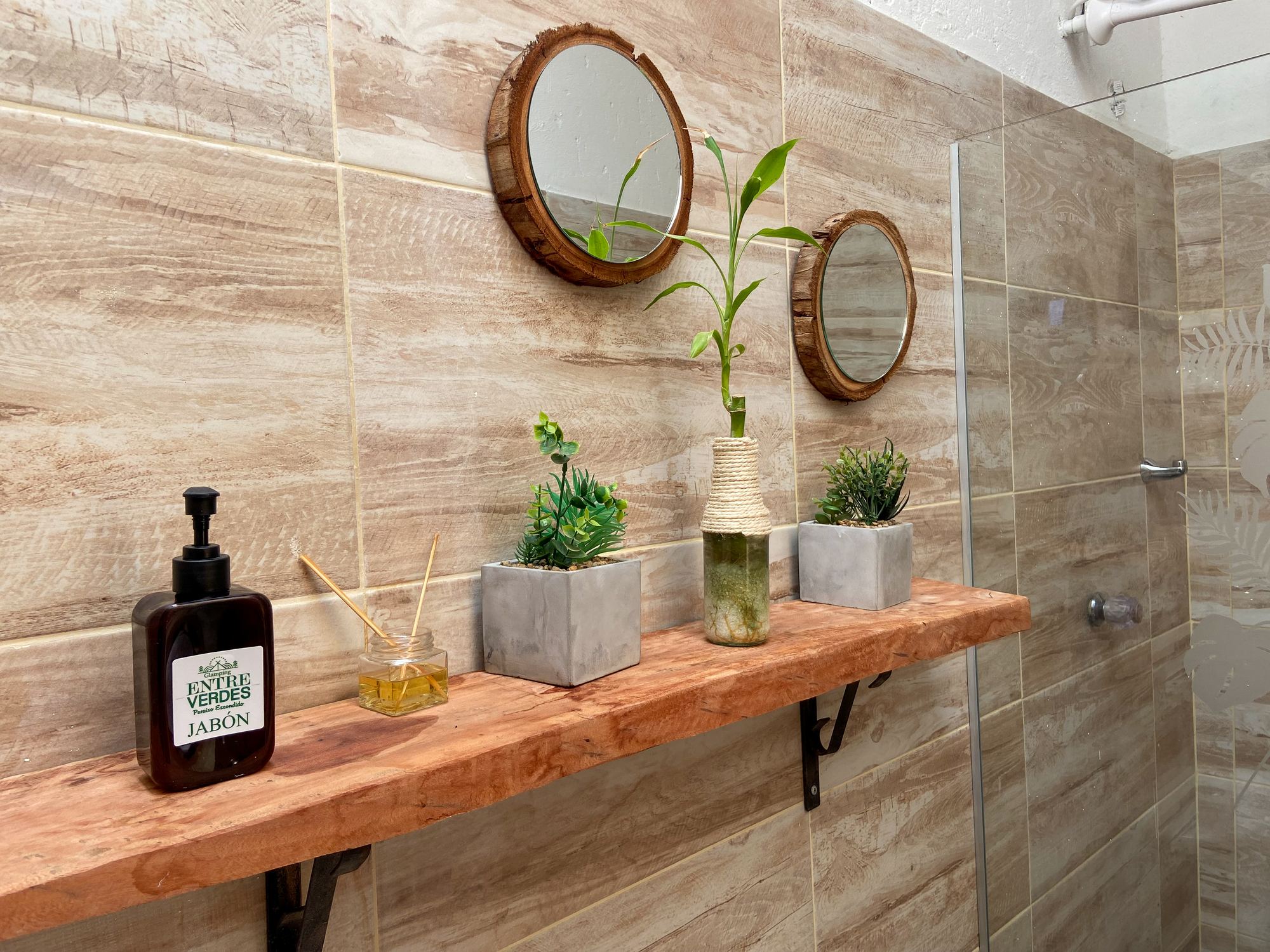 Bathroom shelf with plants, round mirrors and house-brand soap
