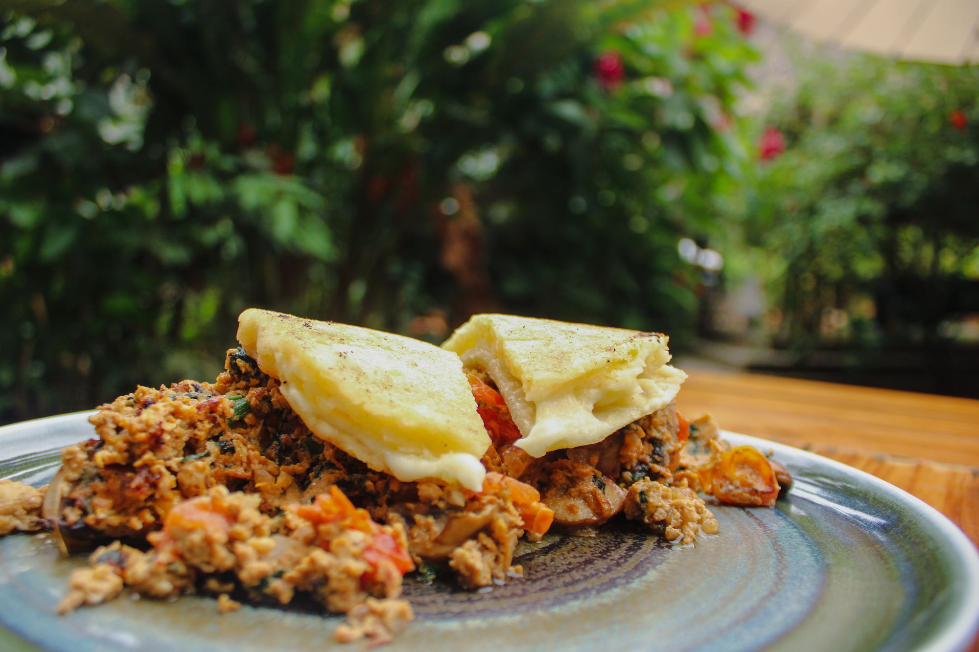 Breakfast plate with fried eggs, served outdoors among plants