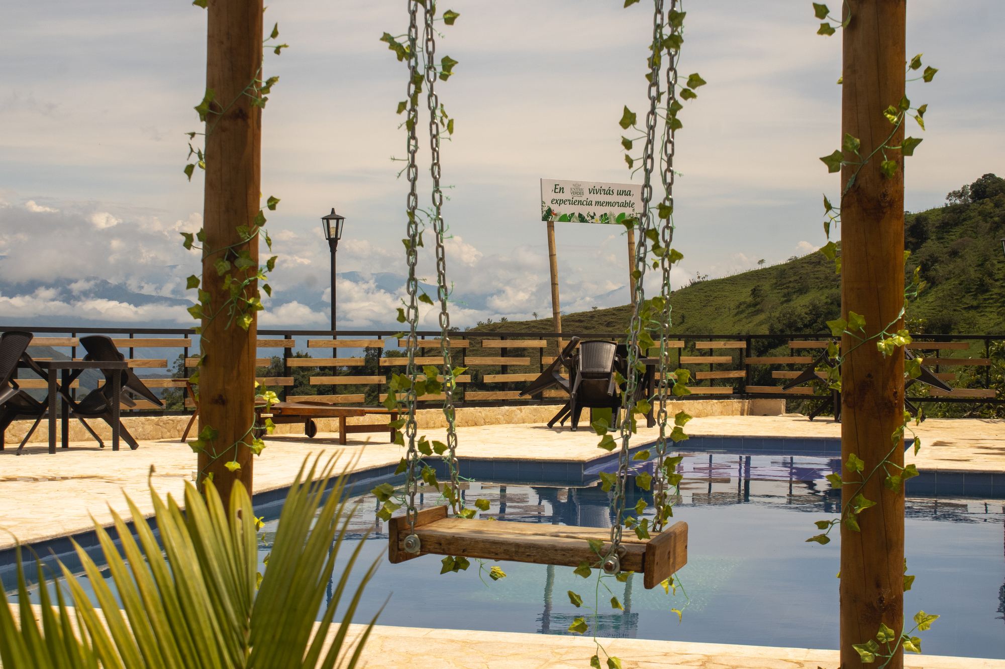 Swing set over a pool terrace with mountains behind